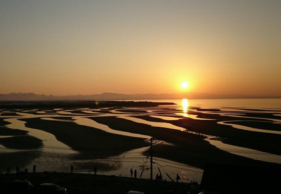 干潟に連続する洲と澪が海に沈む夕陽を演出する真玉海岸