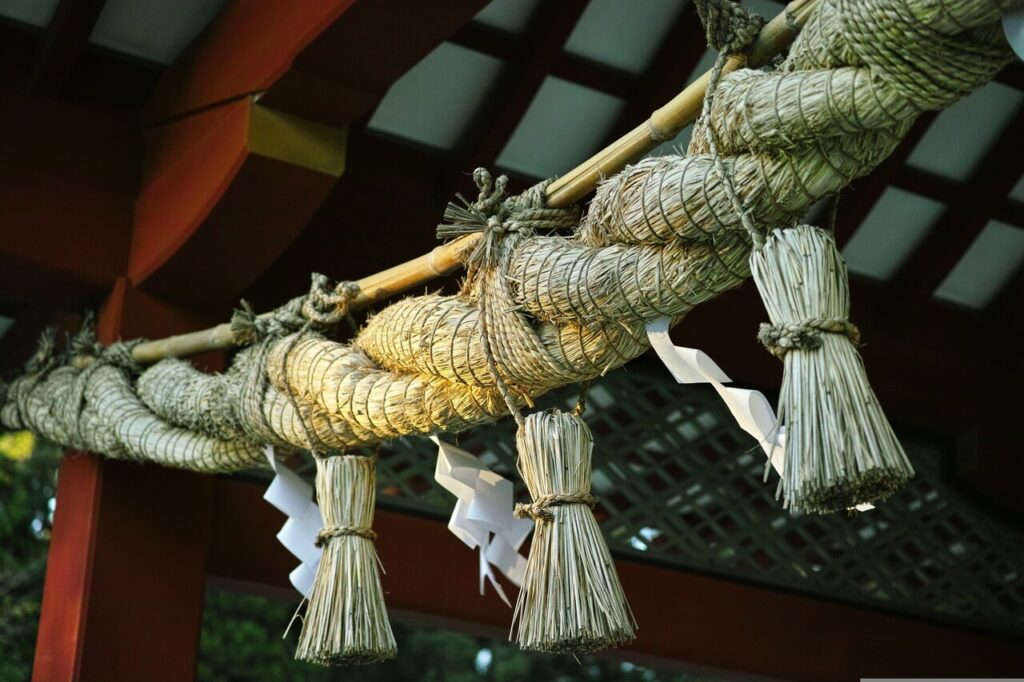 神社の本殿に掛けられたしめ縄を下から見上げた様子