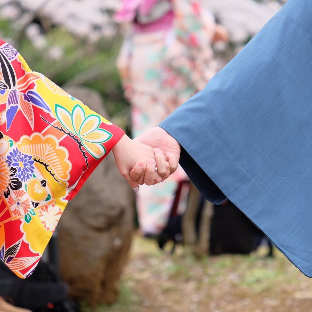 着物を着た男女が出会橋で手をつなぐ手元。未来へと続く“ご縁”を象徴するワンシーン