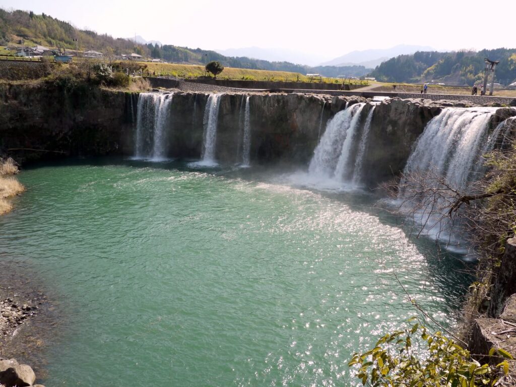 上空から見下ろした原尻の滝と滝つぼ。豊富な水量が広がる川と水面が写り、古くから人々の暮らしを支えてきた水の恵みを感じられる景観