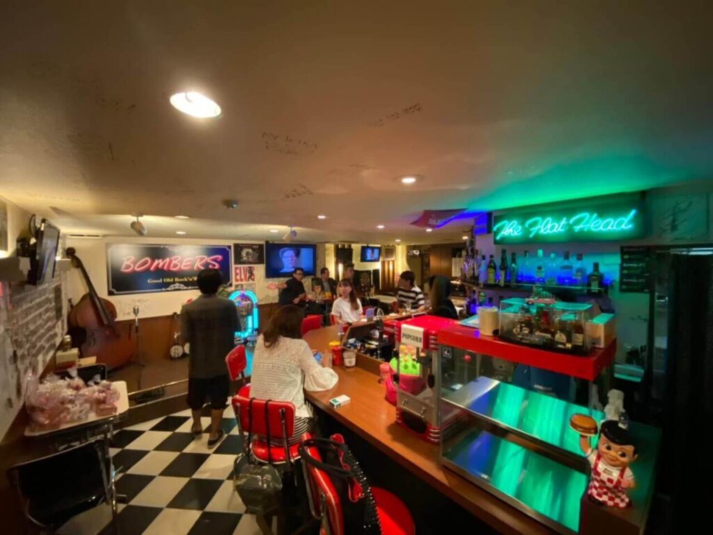 別府のオールディーズバーBombersのネオン輝く店内と賑わう様子