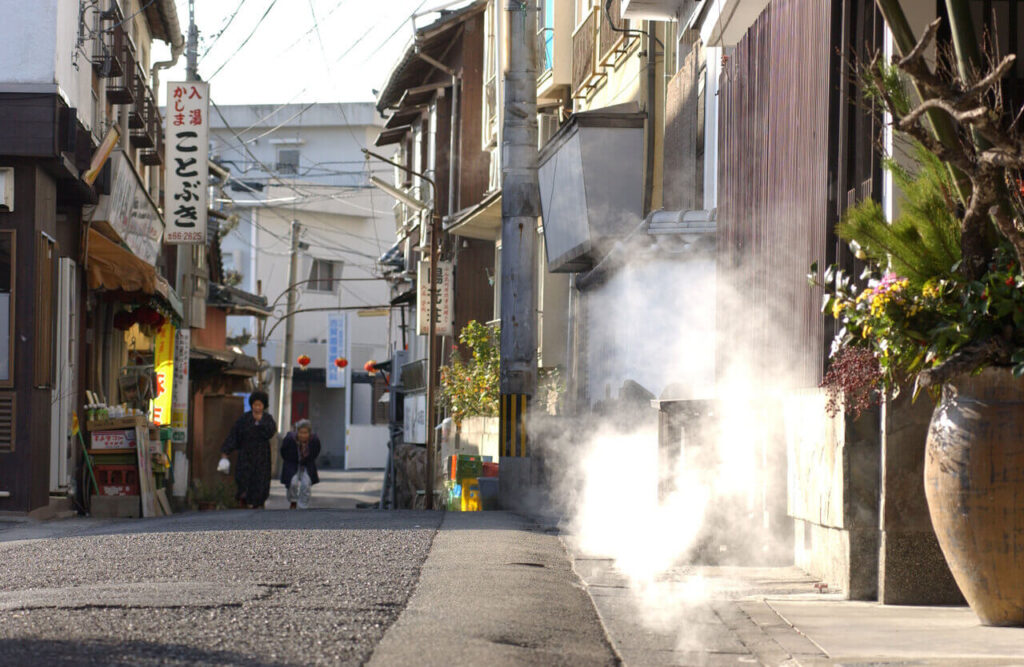 別府の路地裏。側溝から湯気が立ち上る温泉地ならではの風景