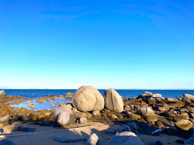 青空と海に囲まれたおしり岩の風景、黒津崎海岸の自然スポット
