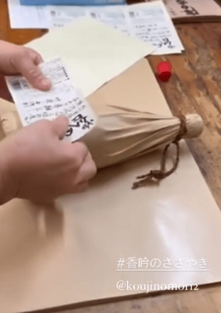 ぶんご銘醸で麦焼酎『香吟のささやき』のラベルを貼る仕上げ作業の様子