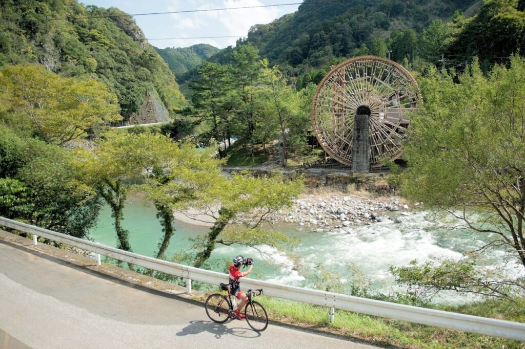 サイクリングと大分県佐伯市の番匠川と水車のある風景