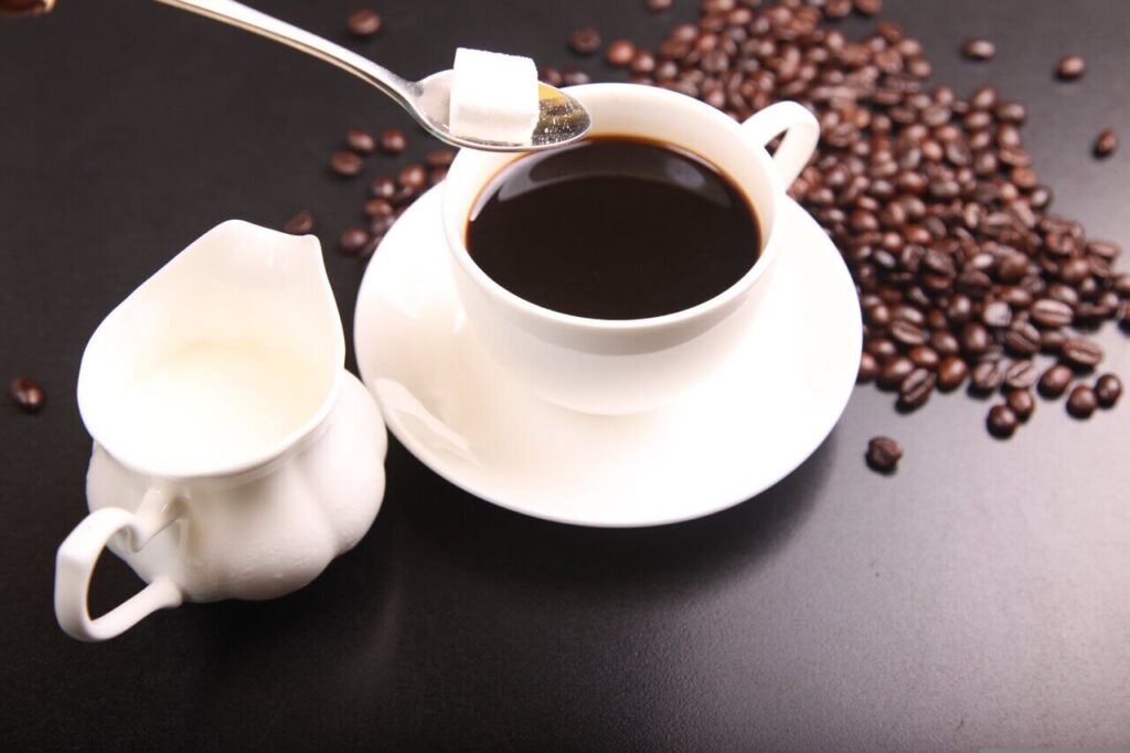 挽きたてコーヒーとミル・砂糖が並ぶ喫茶店のイメージ写真