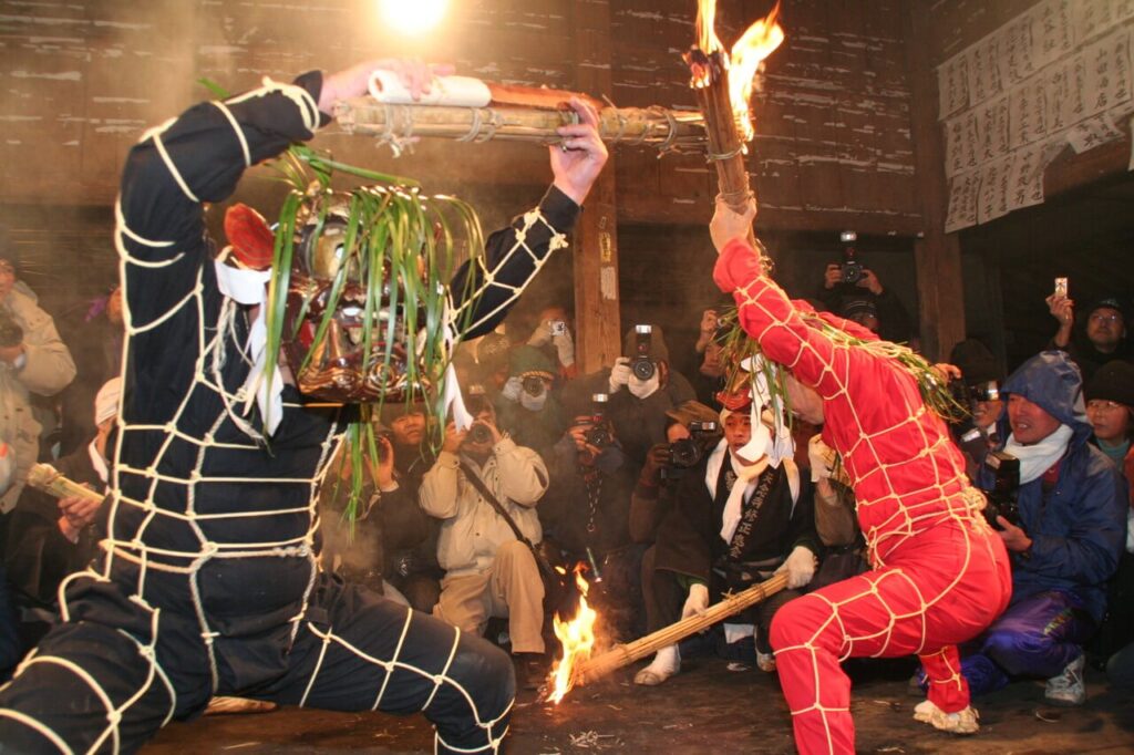 天念寺の修正鬼会で赤鬼と黒鬼の僧侶が松明を持って舞う様子