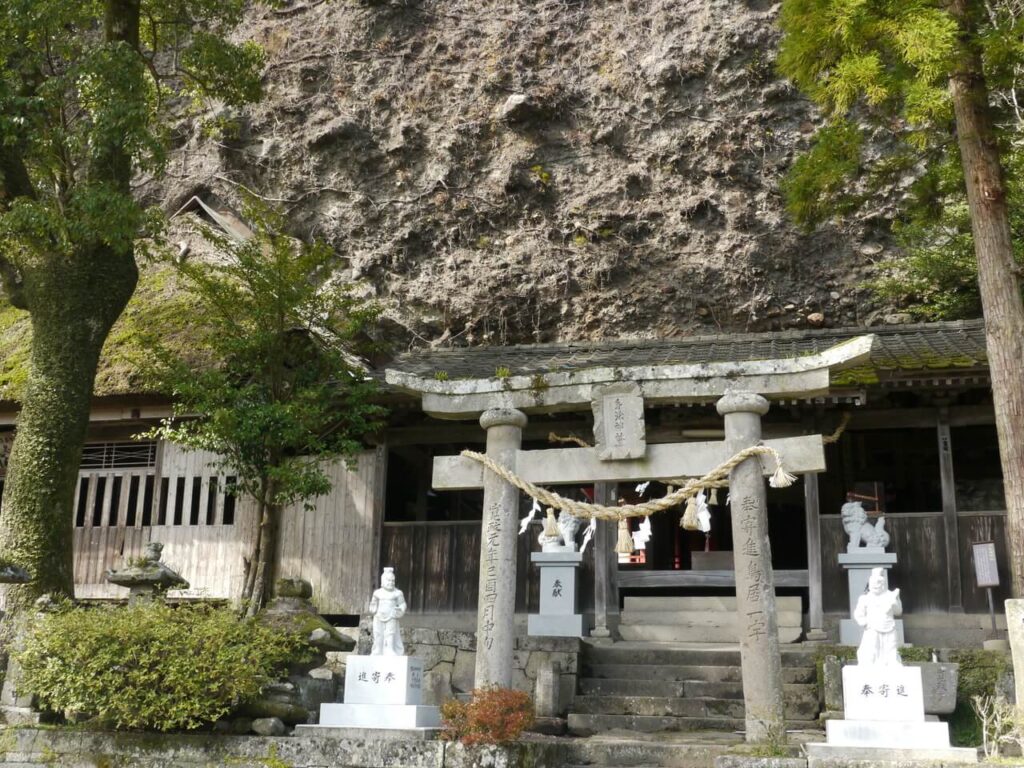鳥居の奥に渡り廊下と岩山が見える天念寺の身濯神社
