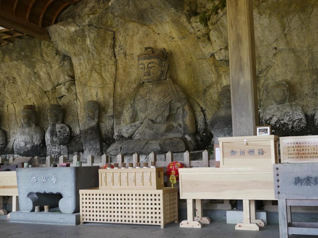 臼杵石仏 古園石仏と並ぶ石仏群と賽銭箱・供物のある祈りの風景