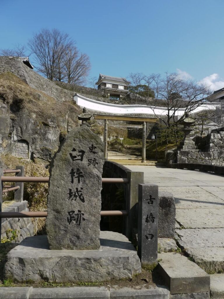 大友宗麟が築城した歴史を伝える、臼杵城跡の石碑とその奥に佇む立派な石垣