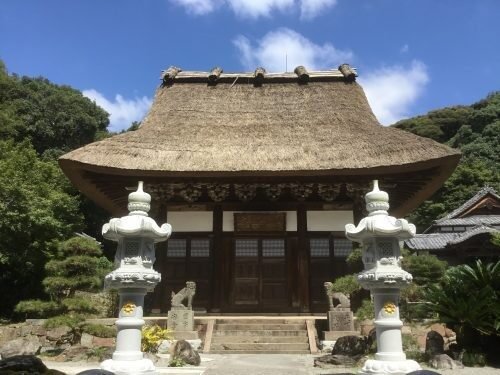 妙徳山泉福寺の茅葺き屋根の本堂(仏殿)と手前に並ぶ一対の石灯籠