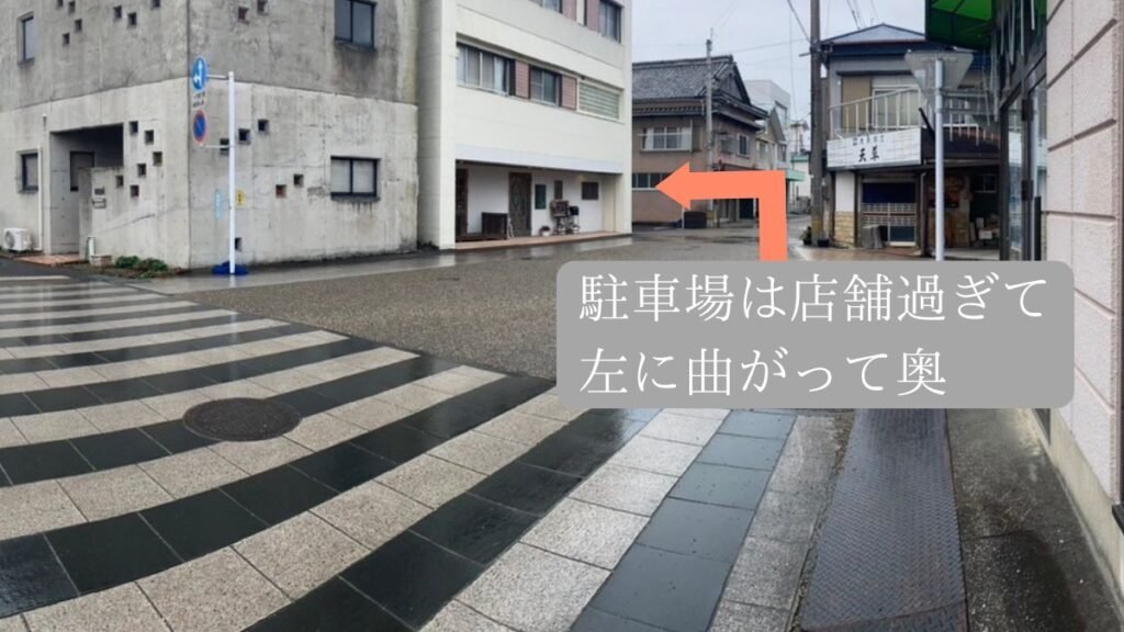 店舗を過ぎた角を左に曲がった先にある駐車場への案内