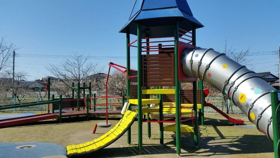 鈴熊山公園どんぐり広場のカラフルな複合遊具。タワーとチューブ型スライド、黄色いローラーすべり台が設置されている